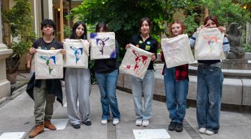 Grupo de jóvenes posando con mochilas realizadas en el taller de esténcil